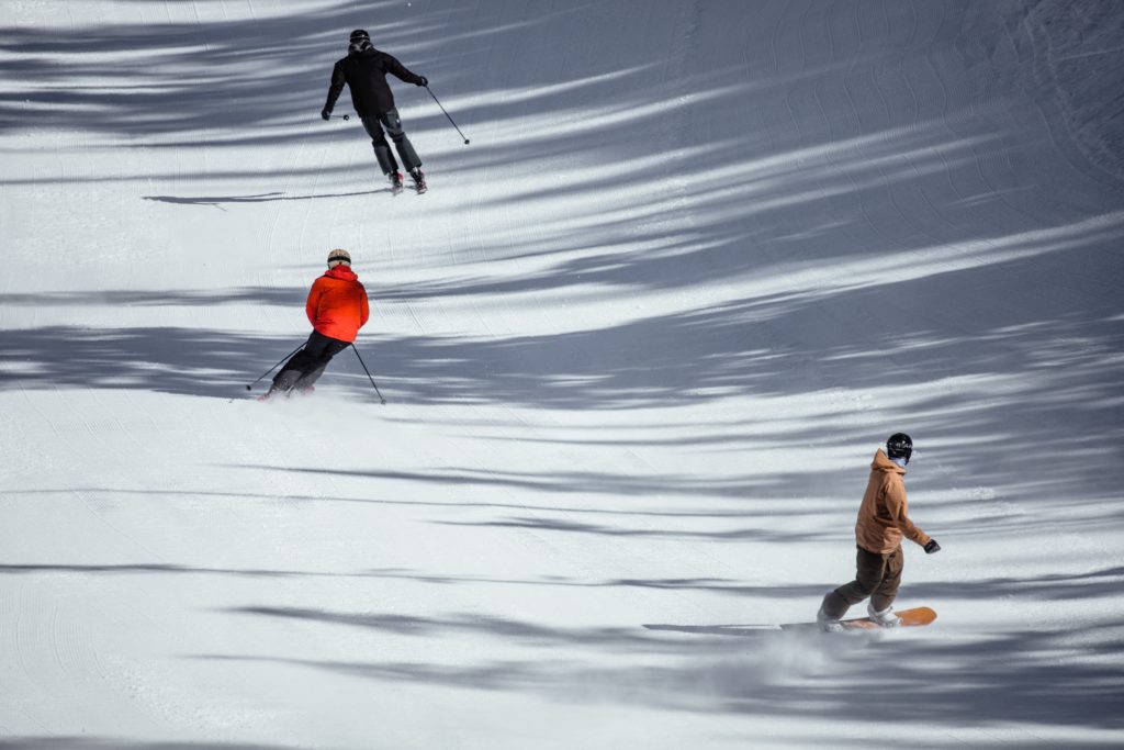 Skiiers and snowboarders going downhill
