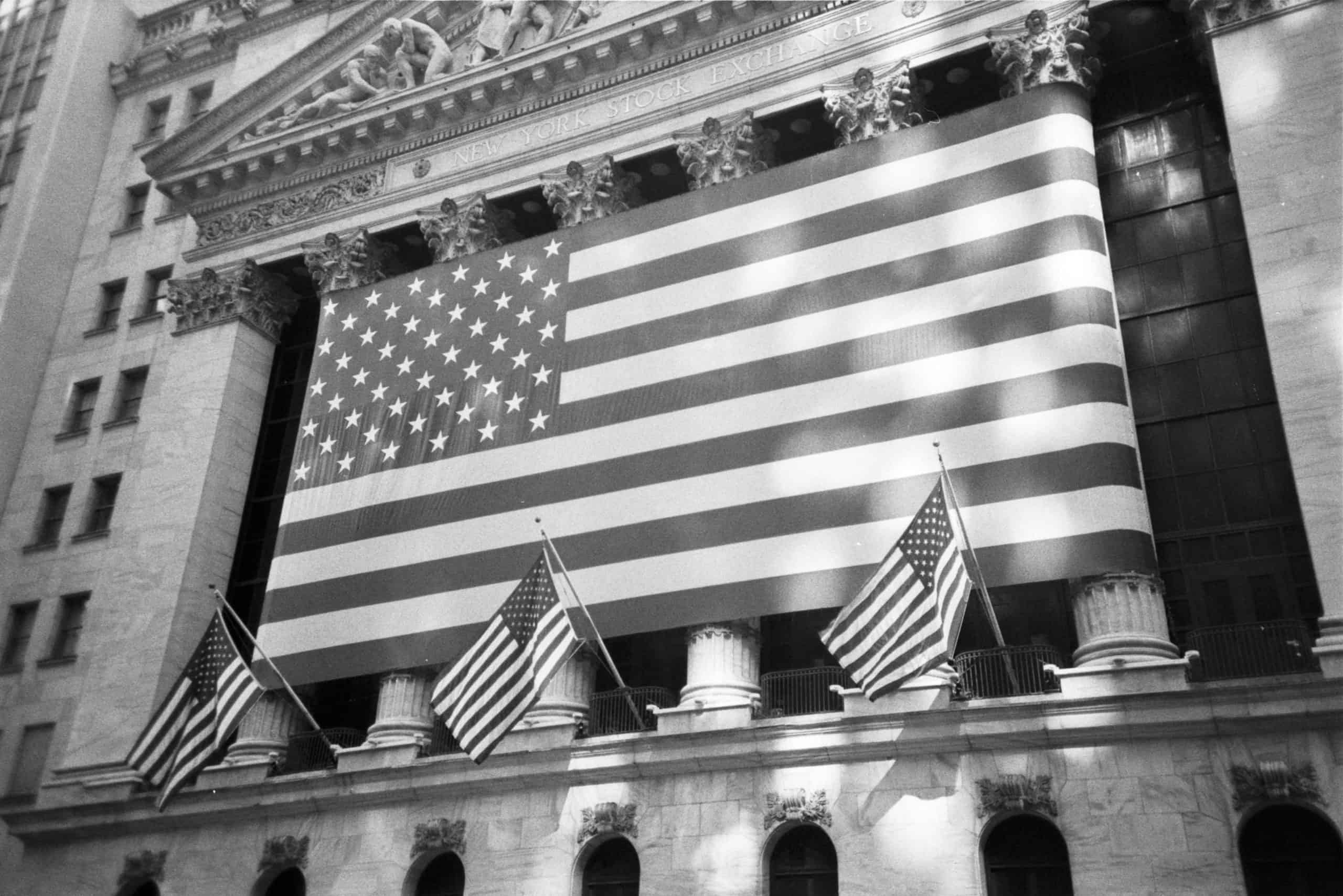 Grayscale filtered image of American flags on Stock Market building