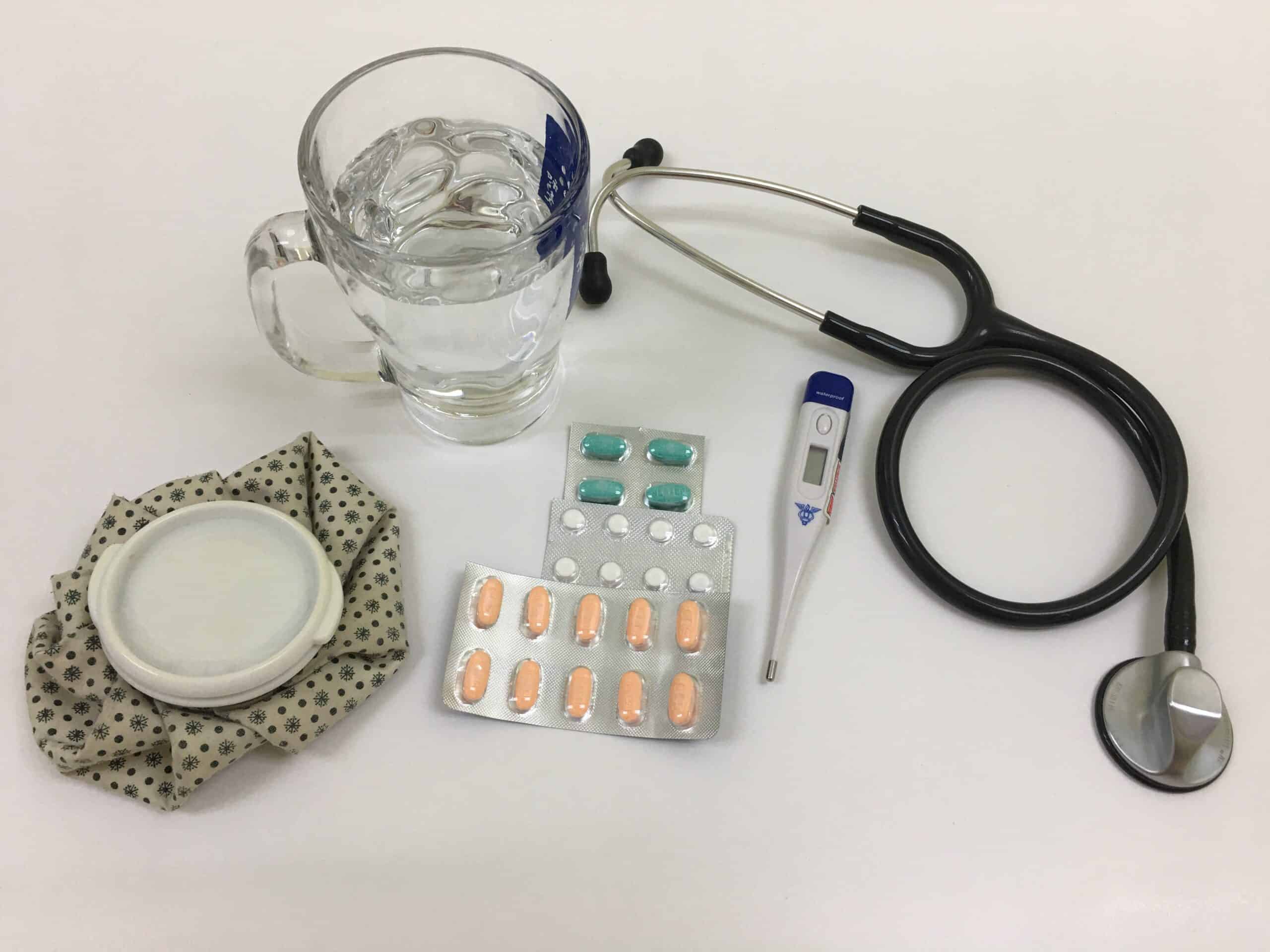 Medicine tablets, stethoscope and cup of water
