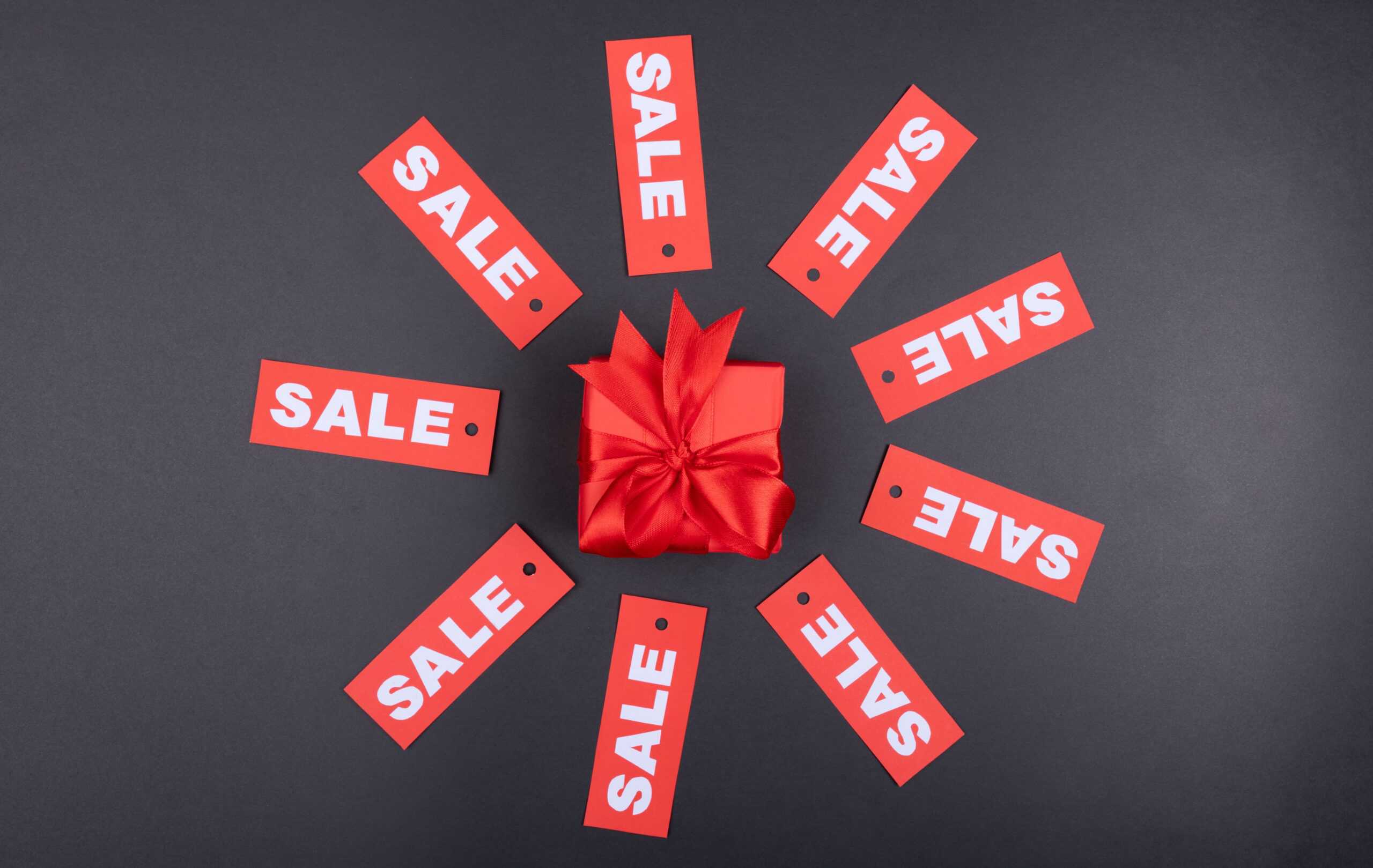 Wrapped present with red box and tags labels sale surrounding the present
