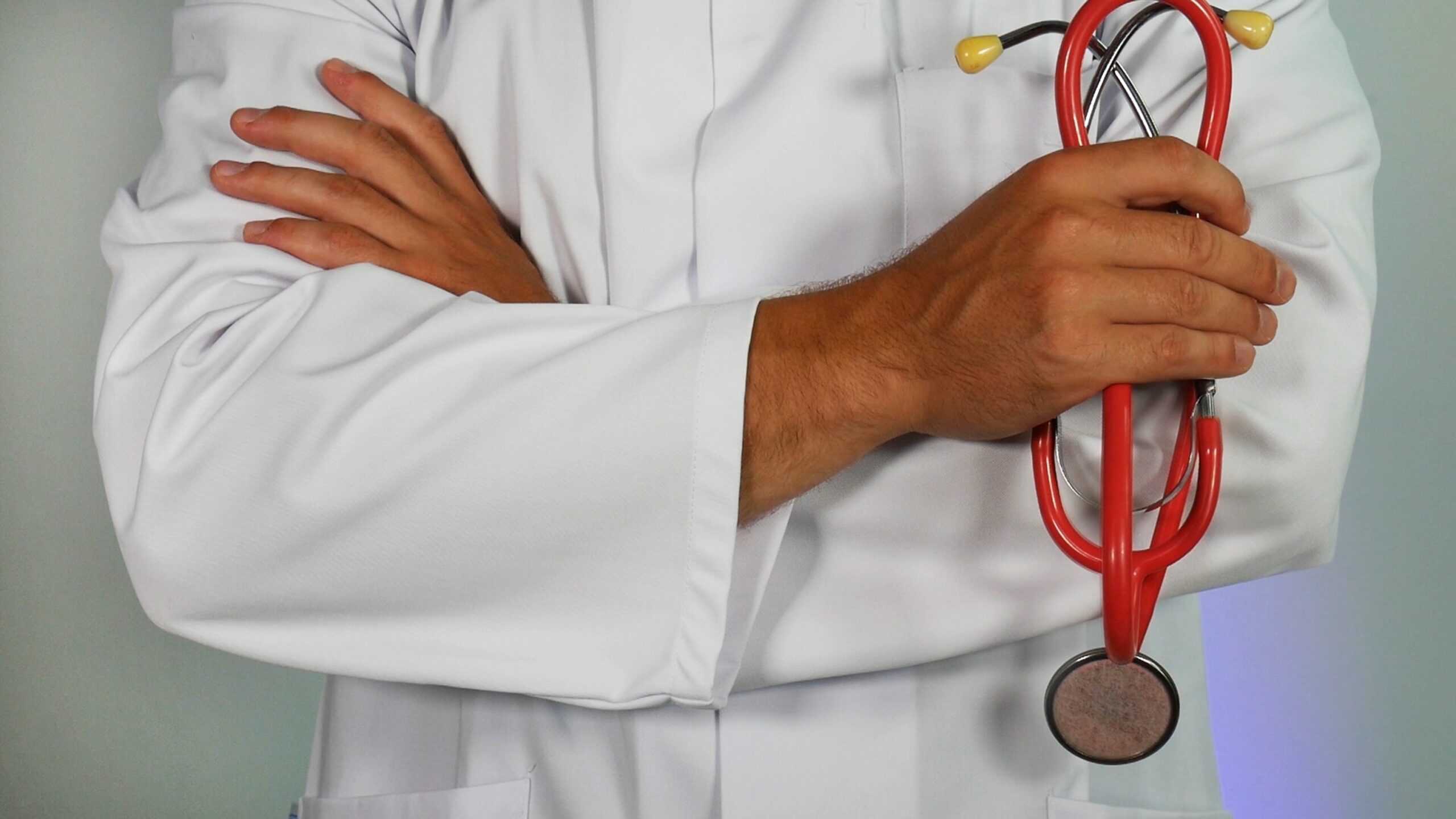 Person in a white doctor coat holding stethoscope