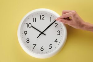 hand adjusting a clock