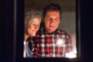 older man and woman holding sparkler